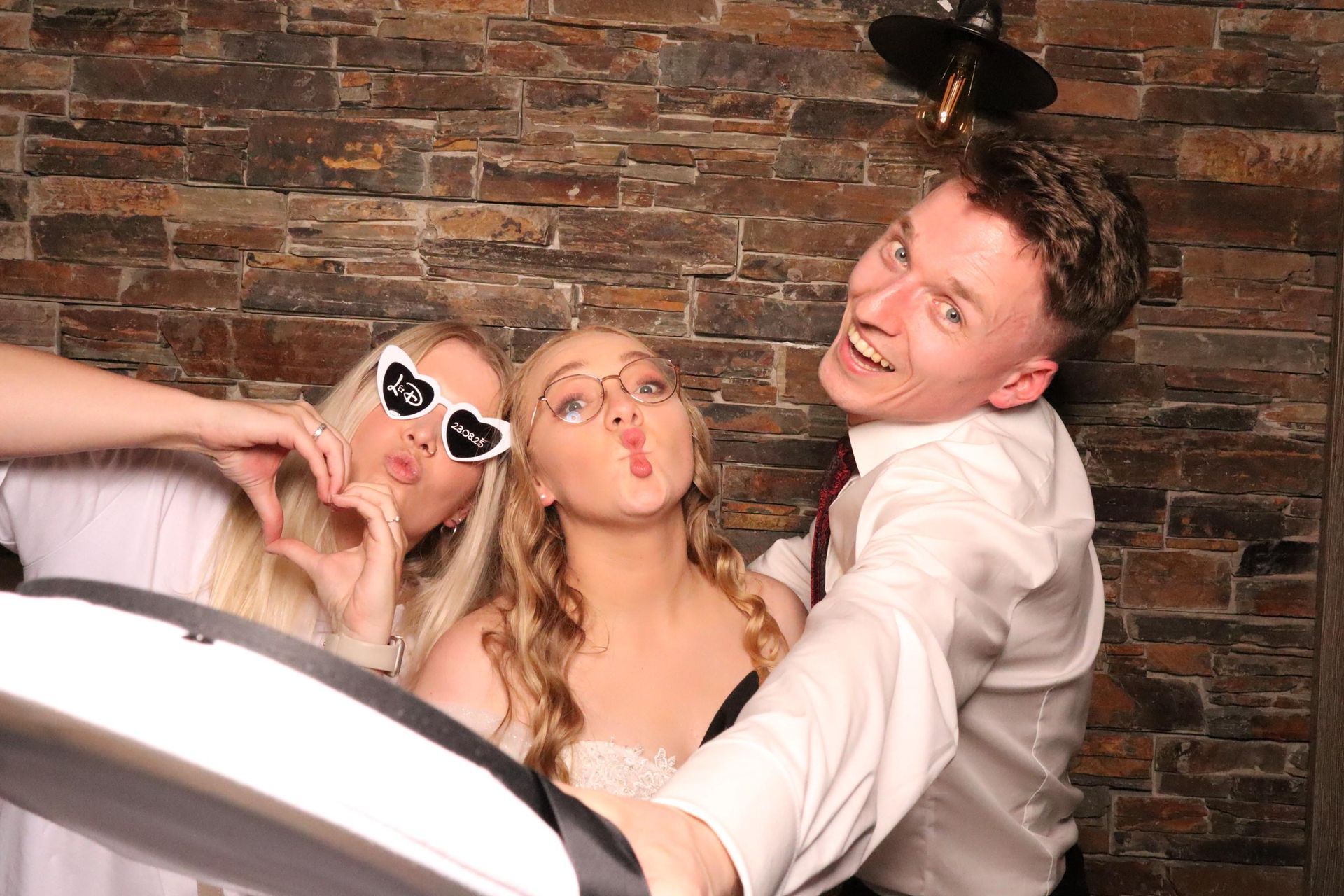 Feiernde Hochzeitsgäste posieren lachend auf der Party.