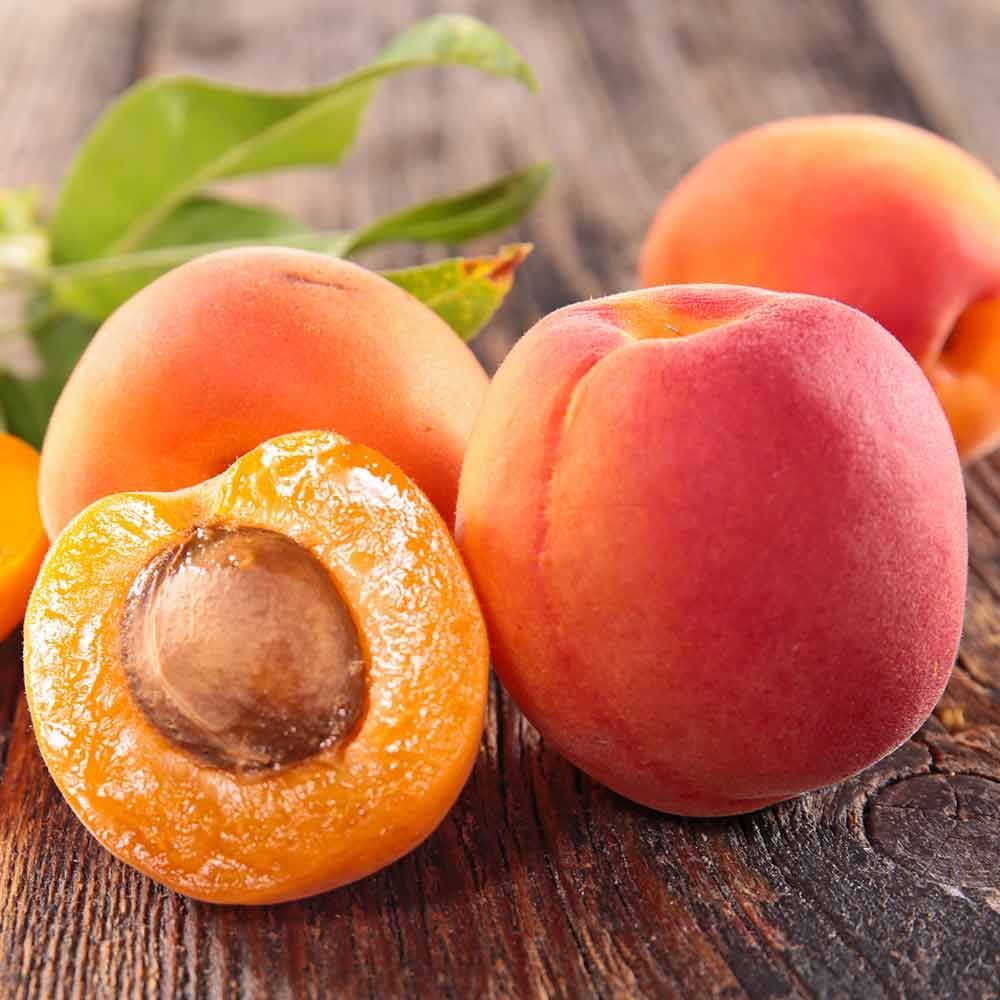 Eine Gruppe Aprikosen auf einem Holztisch.