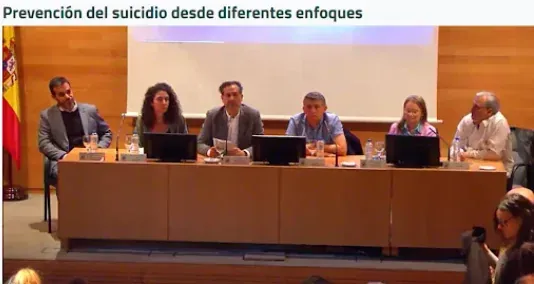 Un panel de seis personas se sienta detrás de una larga mesa en una conferencia 