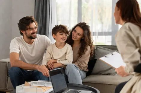 Una familia está sentada en un sofá en una habitación luminosa
