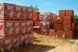 Un montón de ladrillos están apilados uno encima del otro en un campo.