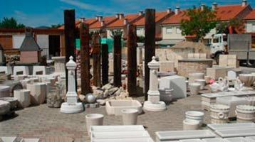 Hay muchas macetas y jardineras en el suelo de un patio.