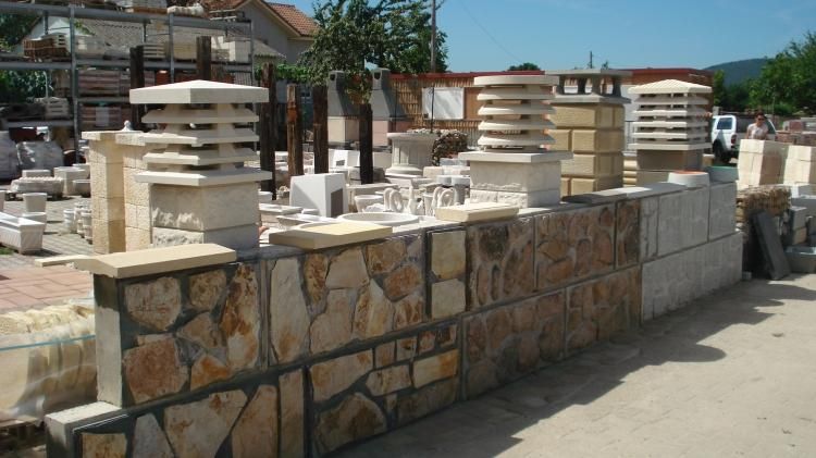 Un muro de piedra con un montón de chimeneas encima.