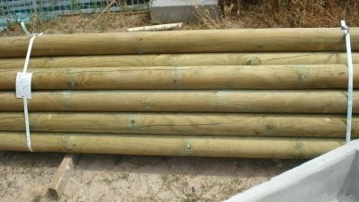 Una pila de postes de madera colocados uno encima del otro en el suelo.