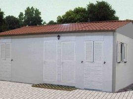 Una casa blanca con techo de tejas rojas y contraventanas blancas.