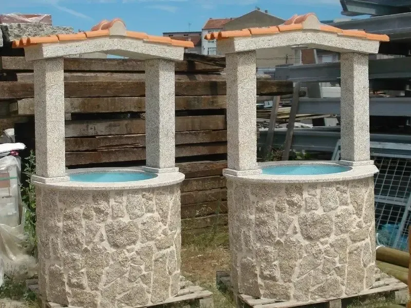 Dos pozos de piedra con tejas naranjas encima