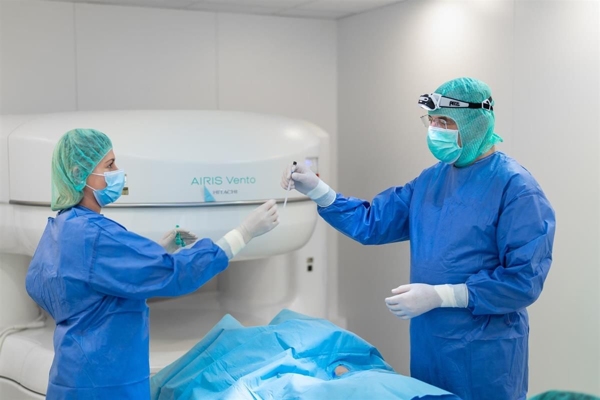 In einem Operationssaal arbeiten zwei Chirurgen an einem Patienten.