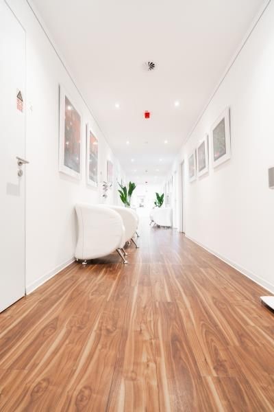 Ein langer Flur mit Holzboden und weißen Wänden