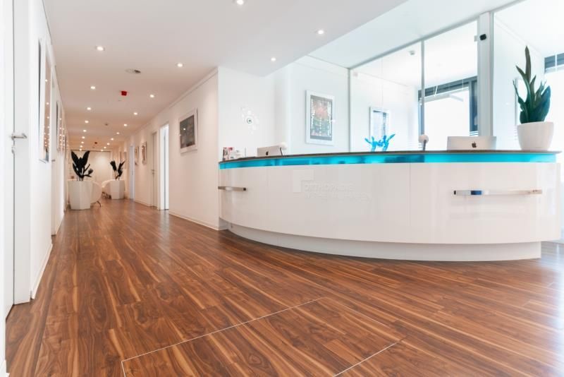 Ein langer Flur mit Holzboden und weißer Theke.