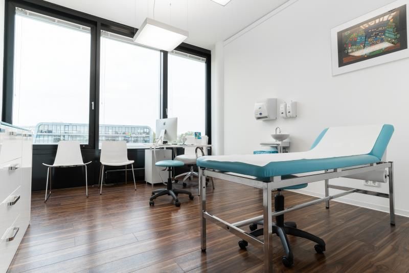 Eine Arztpraxis mit einem blauen Tisch und Stühlen.