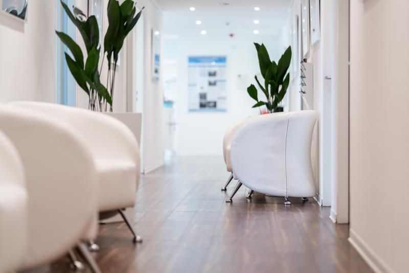Ein Wartezimmer mit weißen Stühlen und Pflanzen