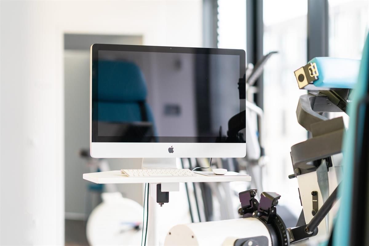 Ein Computermonitor steht auf einem Tisch in einem Raum.