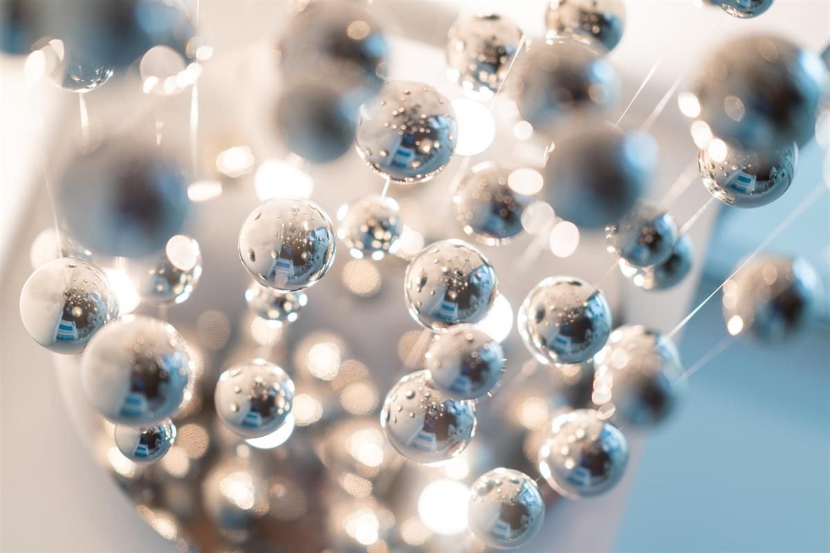 Ein Haufen silberner Kugeln schwebt in der Luft.