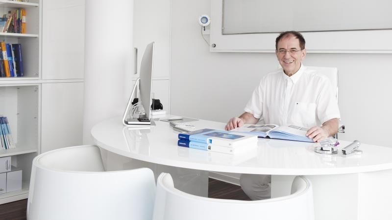 Ein Mann sitzt an einem Schreibtisch vor einem Computer.