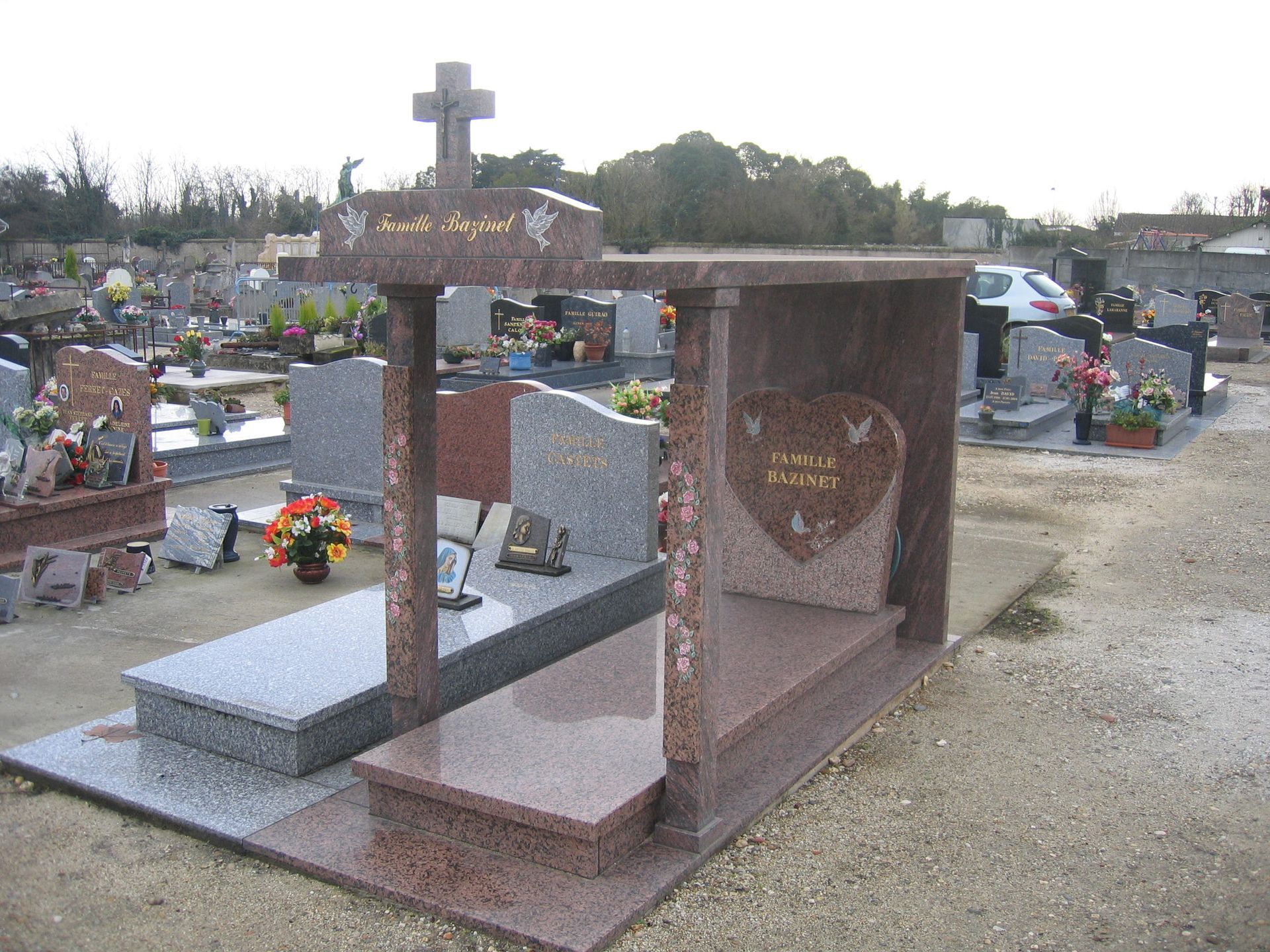 Pierre tombale avec motif de croix et de cœur dans un cimetière.