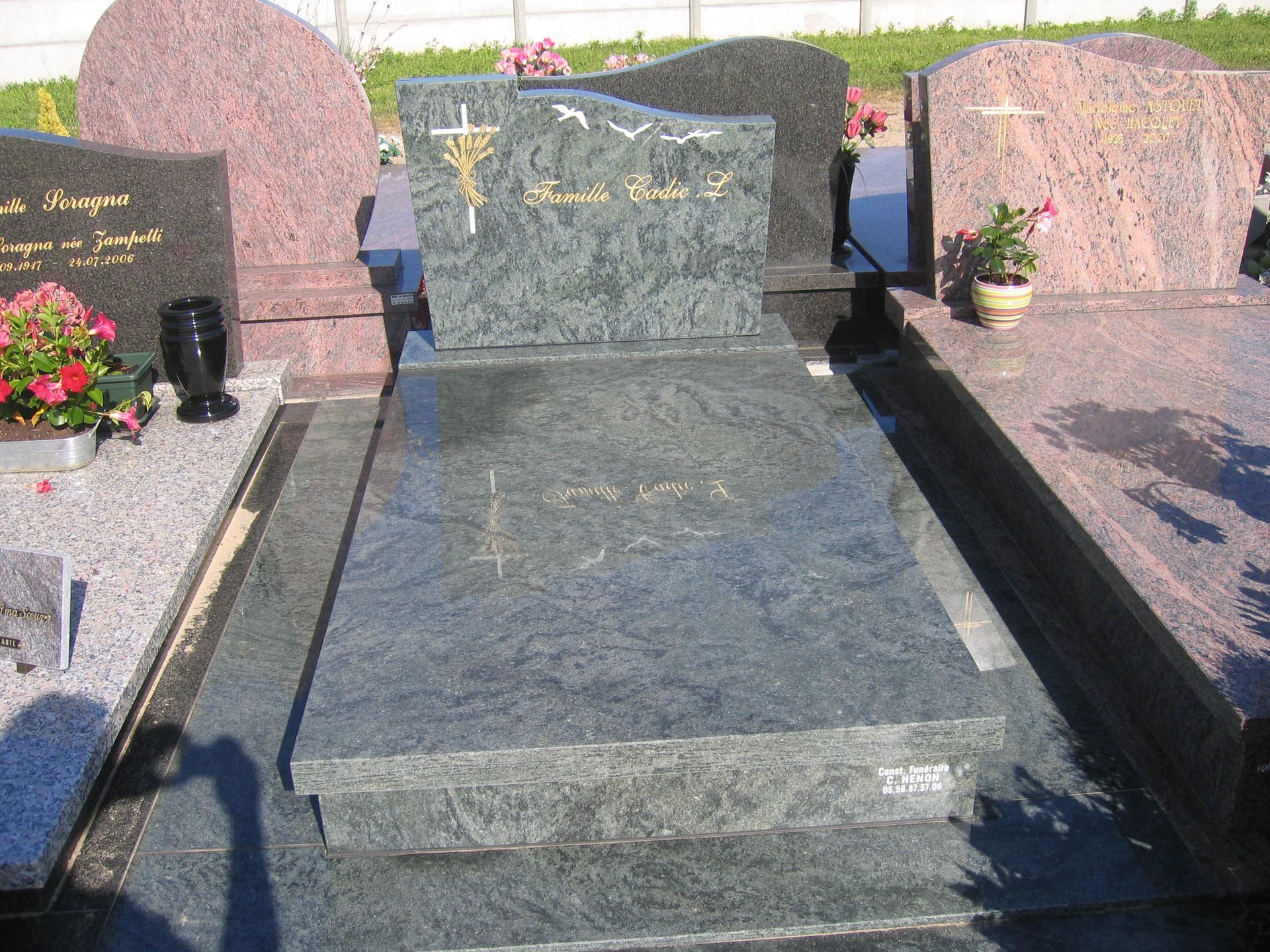 Pierre tombale grise avec décorations blanches et dorées