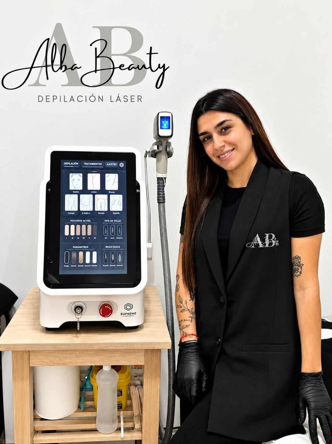 Mujer de pie junto a un aparato facial en una clínica de estética, sonriendo y sosteniendo un teléfono móvil.