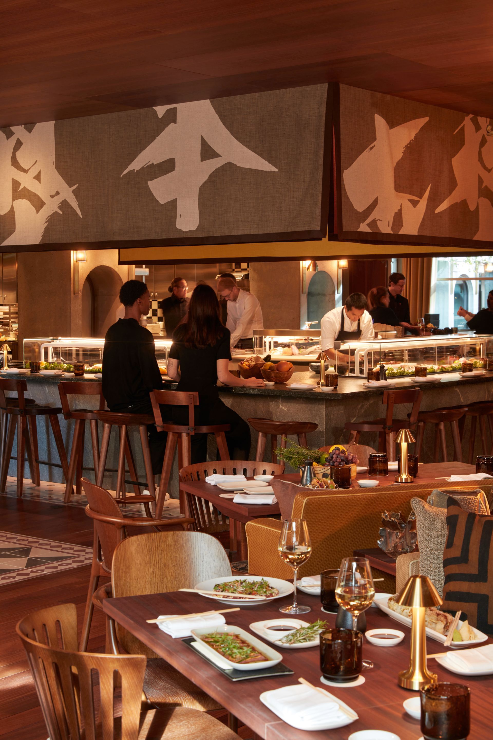 Intérieur du hall avec un bar, un sol au design géométrique et des lustres ornés.
