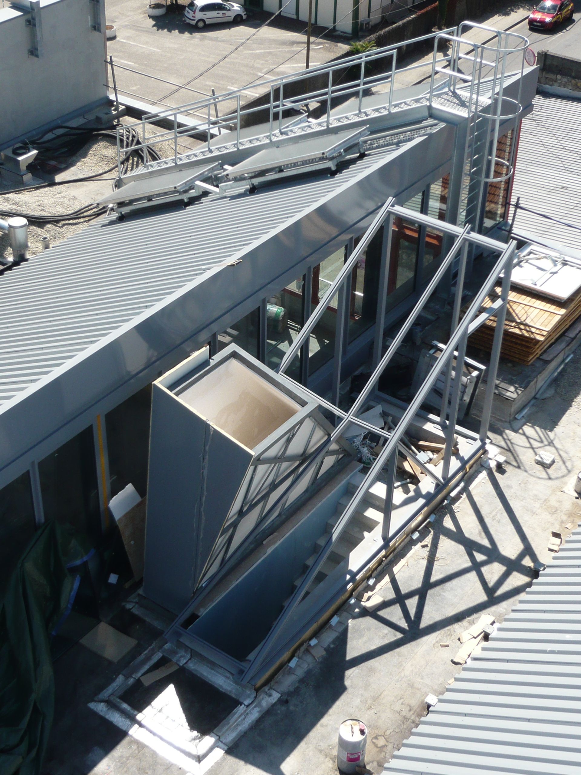 Structure métallique avec rampe et escalier sur le côté d'un bâtiment en construction.