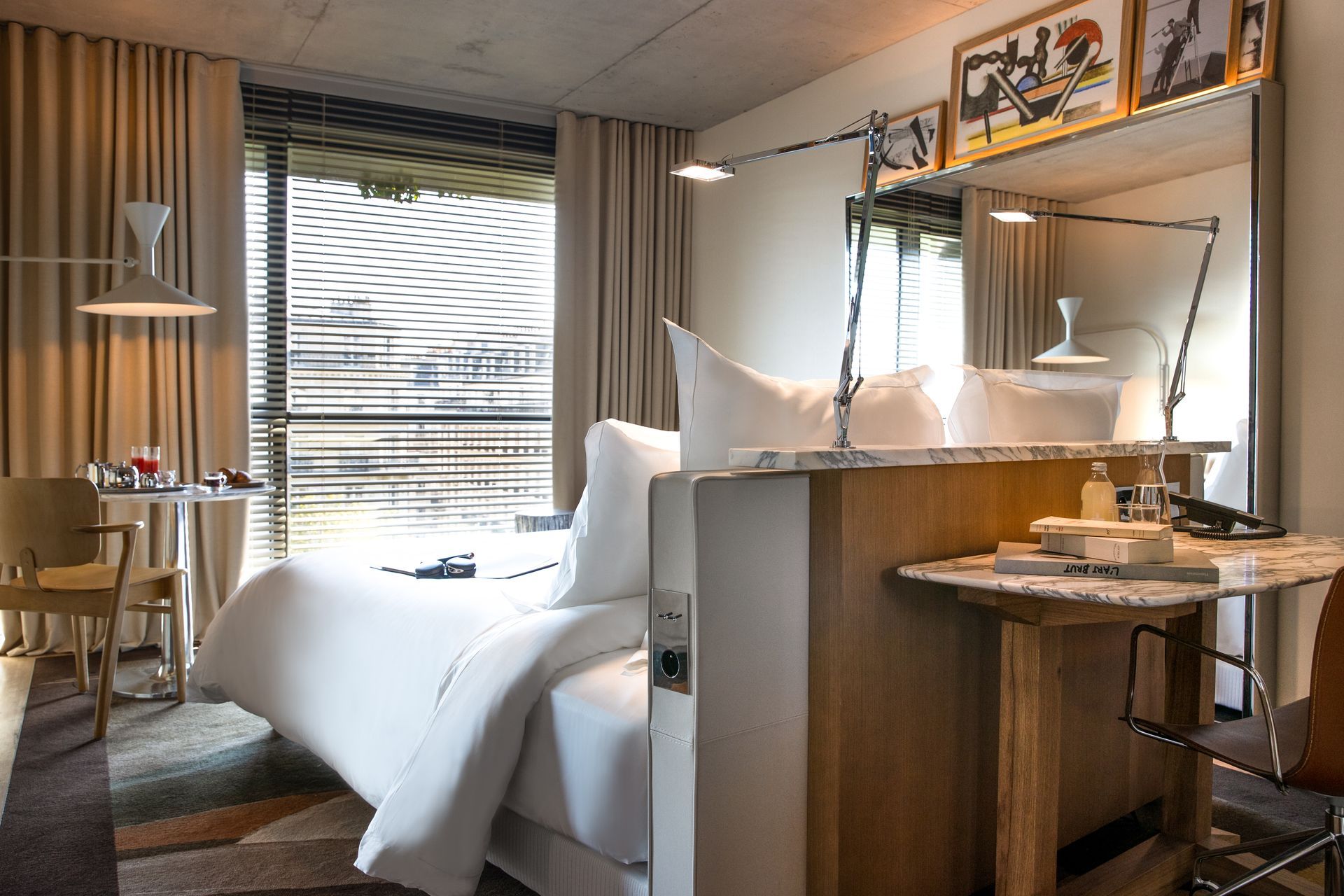 Vue d'une place extérieure ensoleillée avec des bâtiments blancs et des palmiers ; un escalier mène vers le bas.