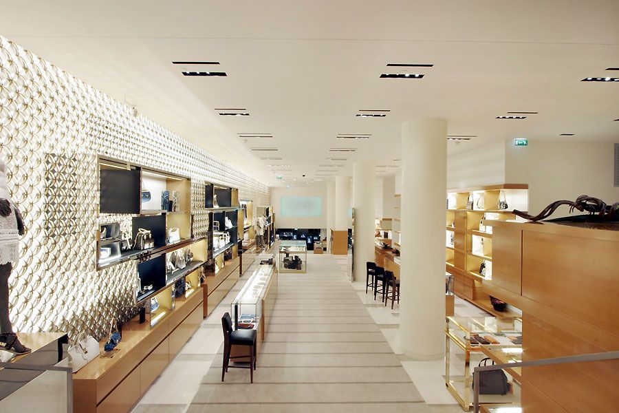 Deux personnes inspectent une zone carrelée autour d'une piscine. L'une porte un casque et tient un dossier.