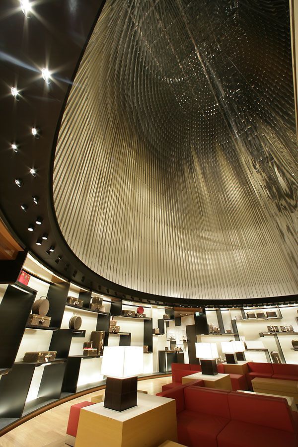Intérieur du hall avec un bar, un sol au design géométrique et des lustres ornés.