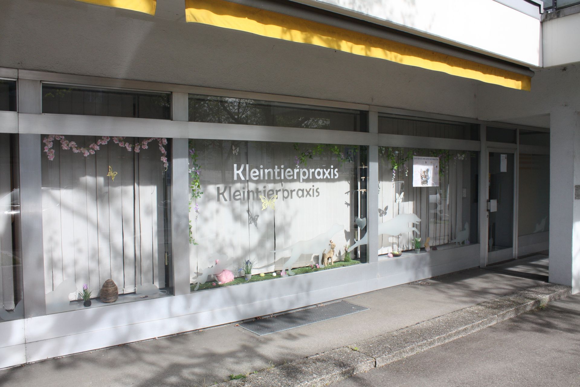 Ein weißes Gebäude mit einer gelben Markise und einem Schild mit der Aufschrift „Klein“