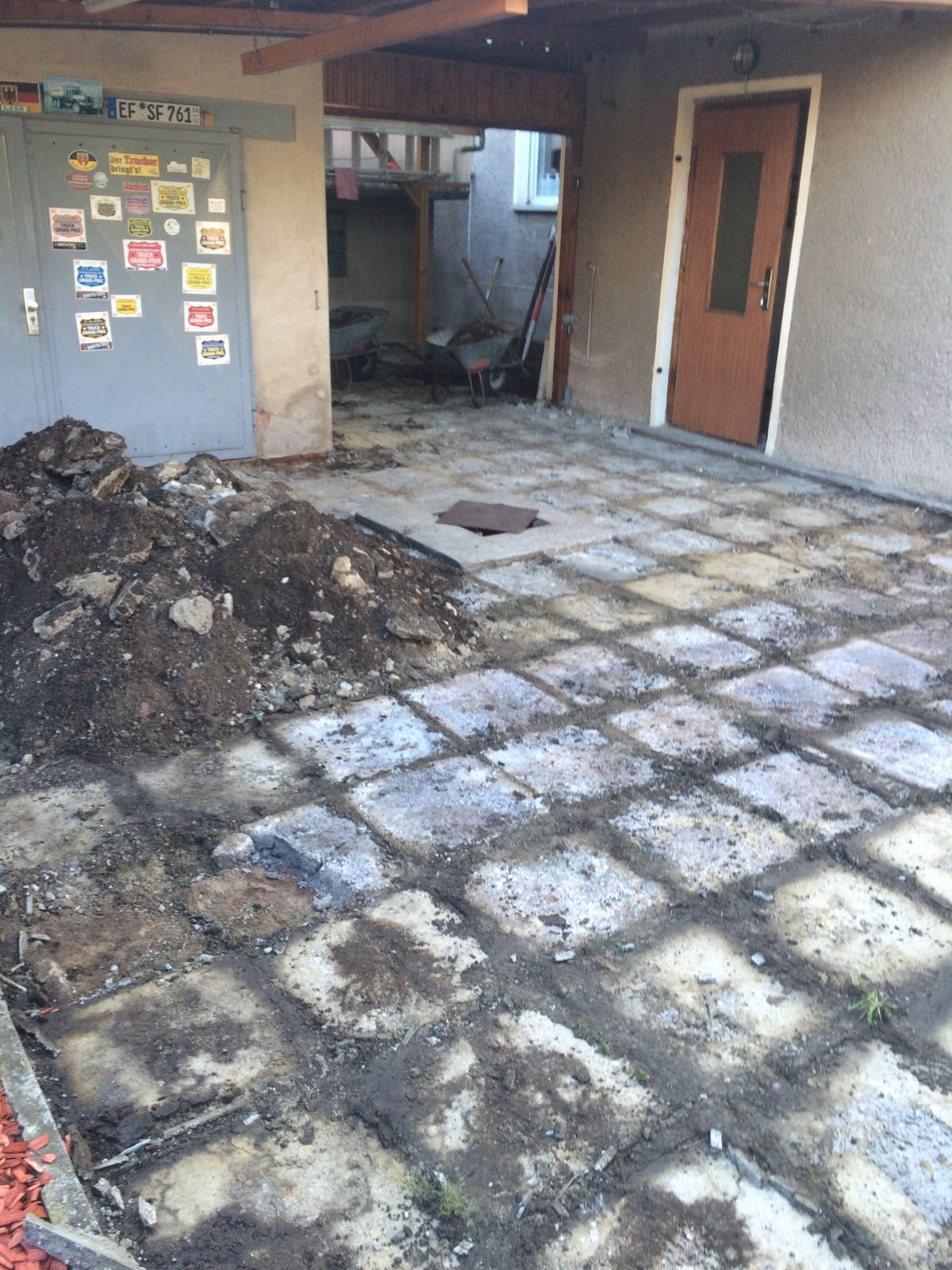 Verkohlte Terrasse mit verbrannten Trümmern und eine versengte Mauer neben einem Hauseingang