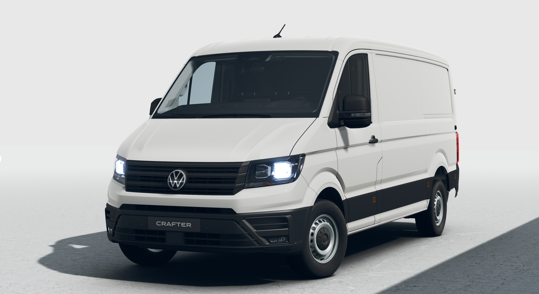 Furgoneta Volkswagen blanca en un estudio, vista frontal izquierda, con las luces encendidas.