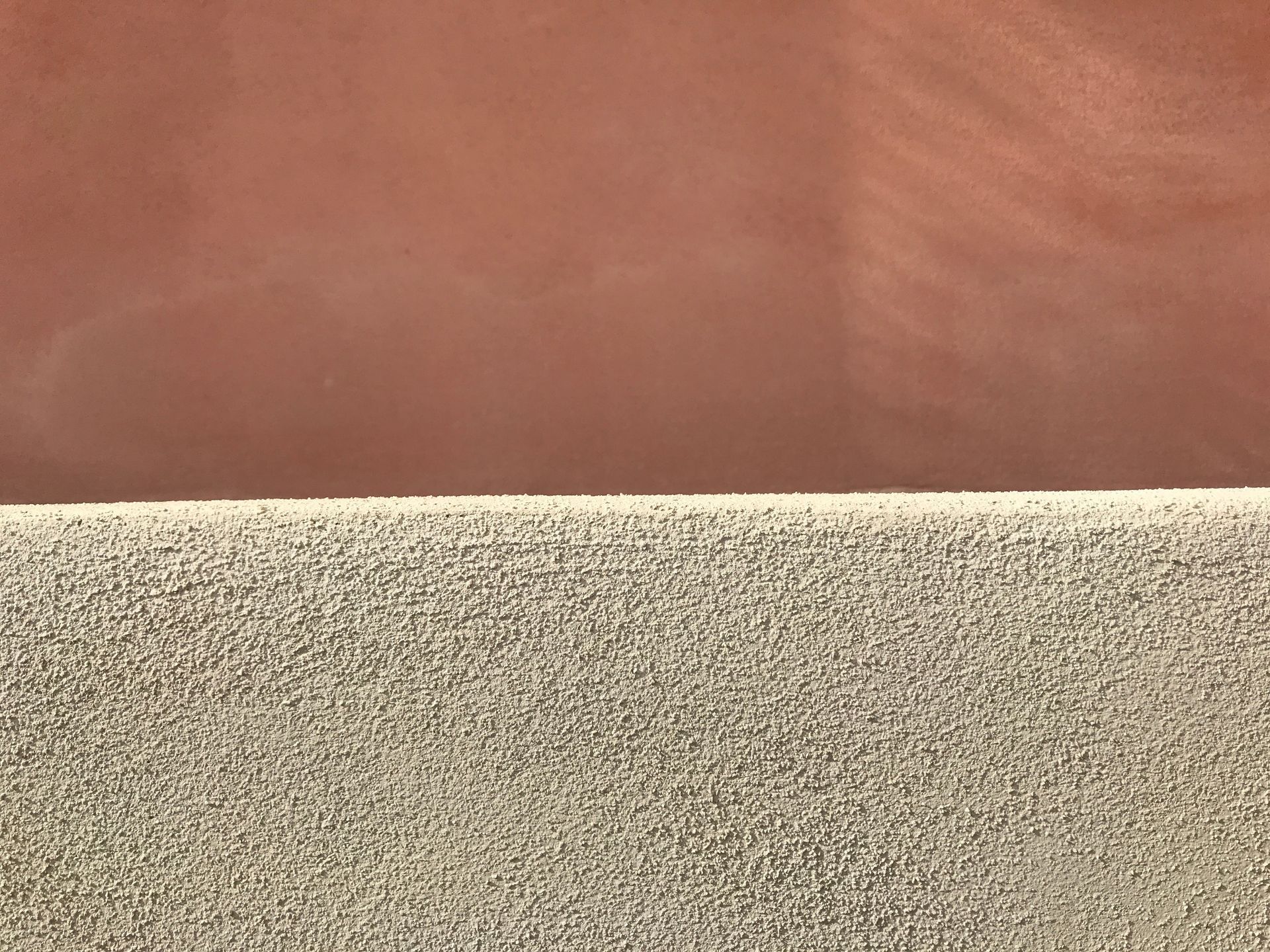 Vue en écran partagé montrant une surface lisse et uniforme brun rougeâtre au-dessus d'une surface texturée, gris clair mouchetée.