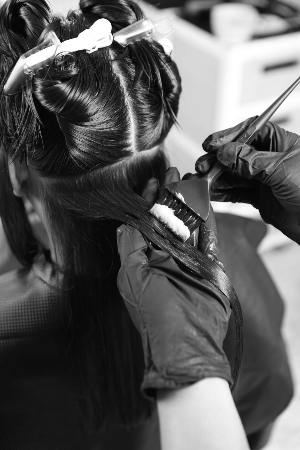 Eine Frau lässt sich in einem Salon von einem Friseur die Haare machen.