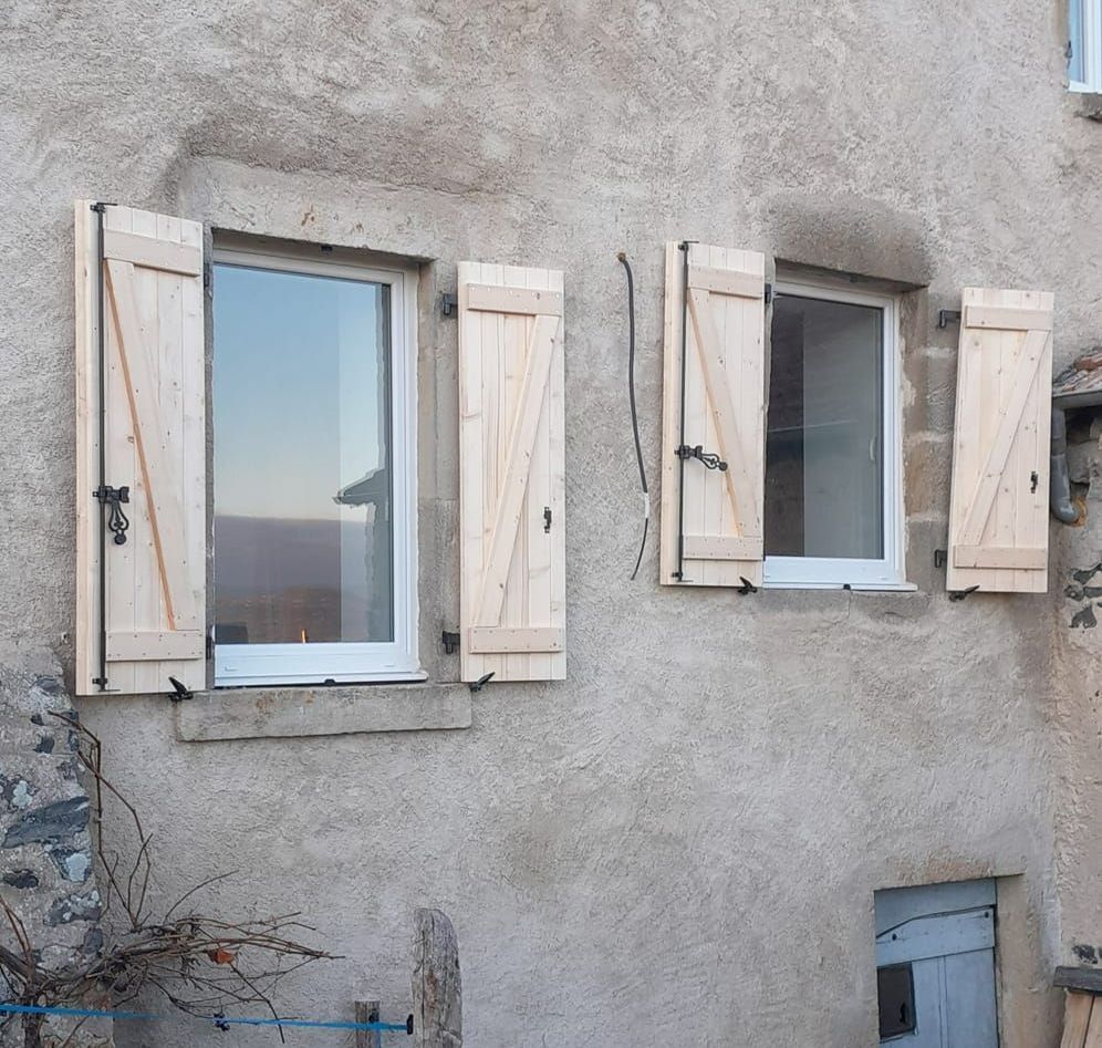 Une façade avec des volets battants en bois 