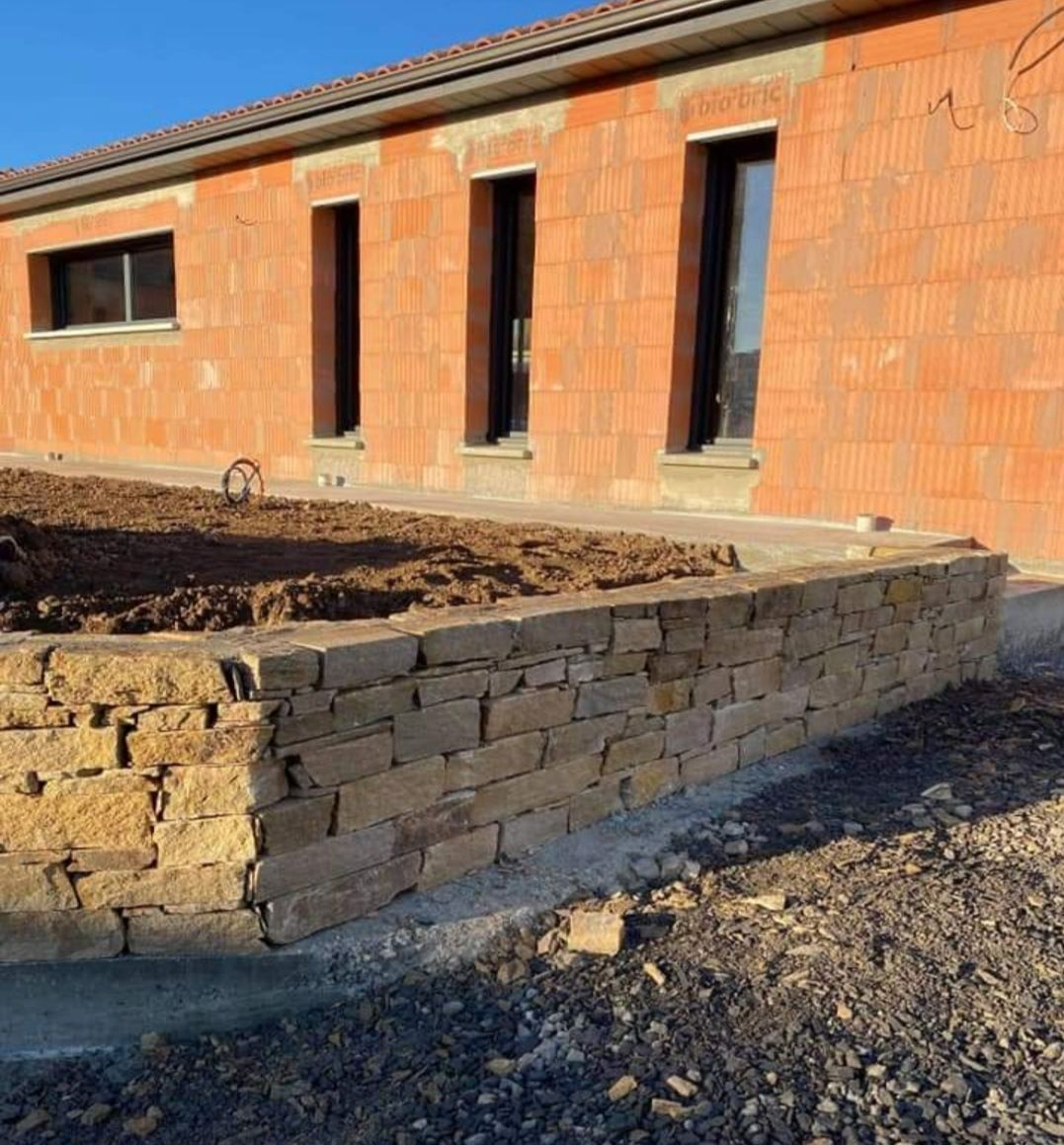 Un mur en brique et un muret en pierre