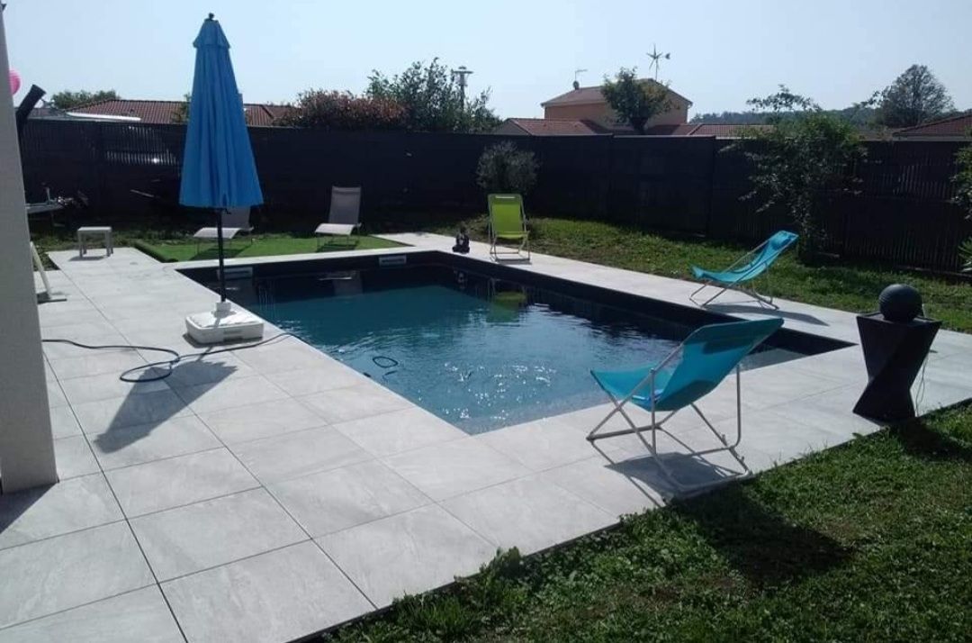 Une piscine creusée et une terrasse carrelée
