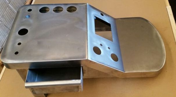 Un trozo de metal con agujeros está sobre una mesa.