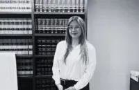 Una mujer está parada frente a una estantería en una foto en blanco y negro.