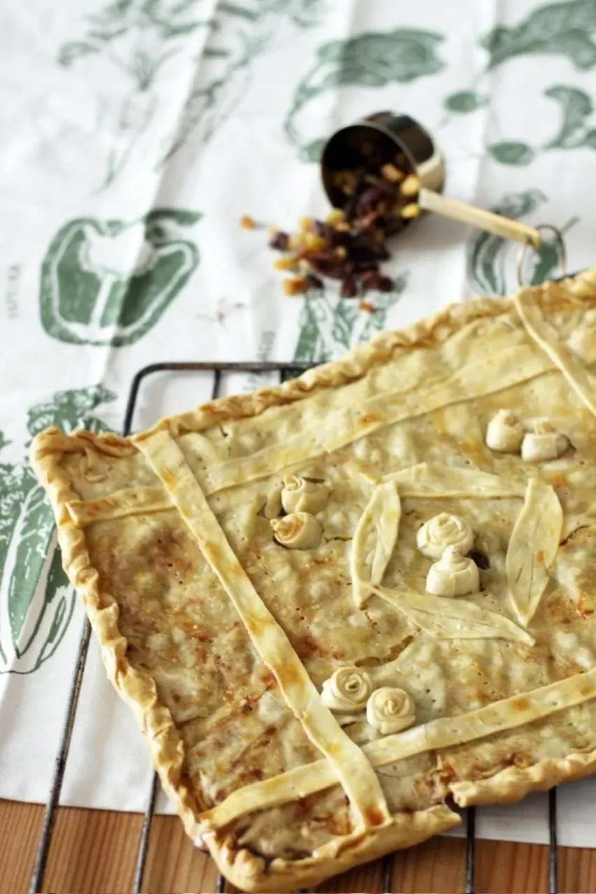 Tarta rectangular con corteza enrejada, sobre una rejilla de alambre encima de un paño verde estampado