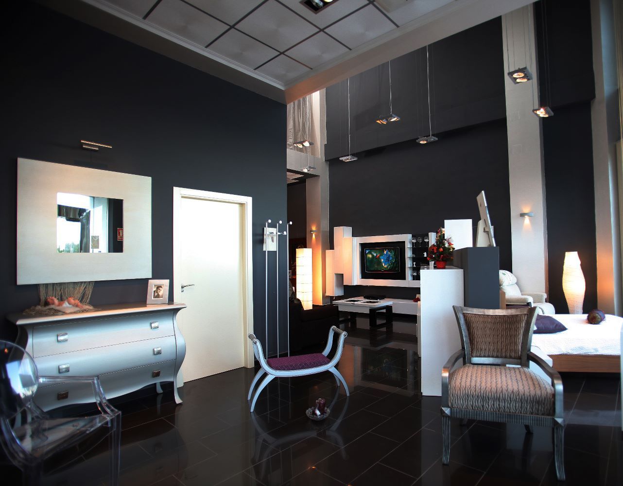 Una sala de estar con paredes negras y muebles blancos.