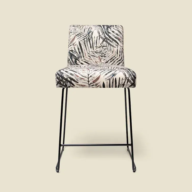 Un taburete de bar con un estampado floral está sobre un fondo blanco.