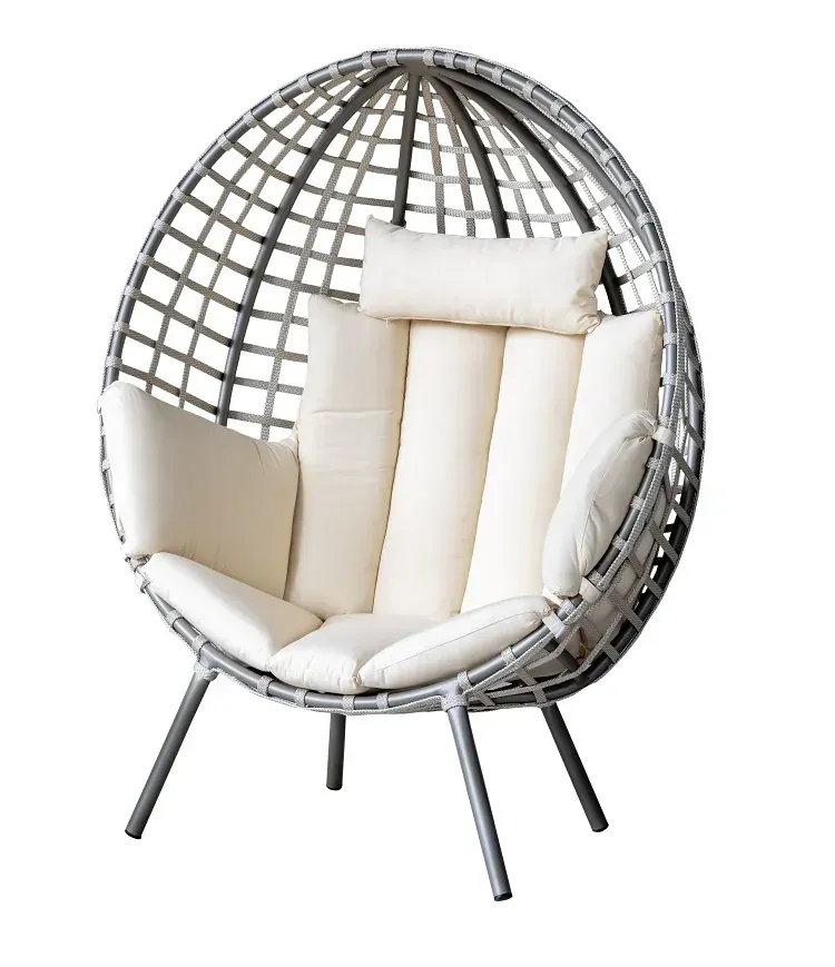 Una silla de mimbre con un cojín blanco sobre un fondo blanco.