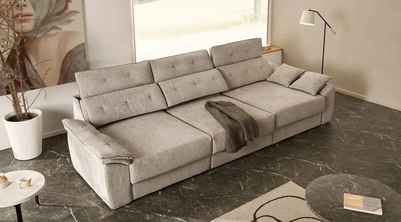 Un gran sofá está sentado en una sala de estar al lado de una lámpara.