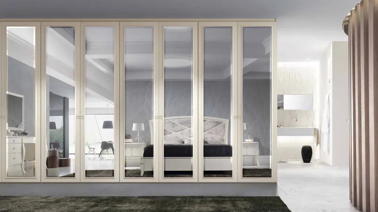 Un dormitorio con cama y puertas con espejo.