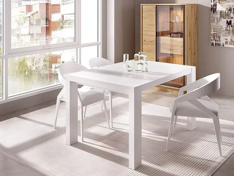 Un comedor con una mesa y sillas blancas y una ventana.