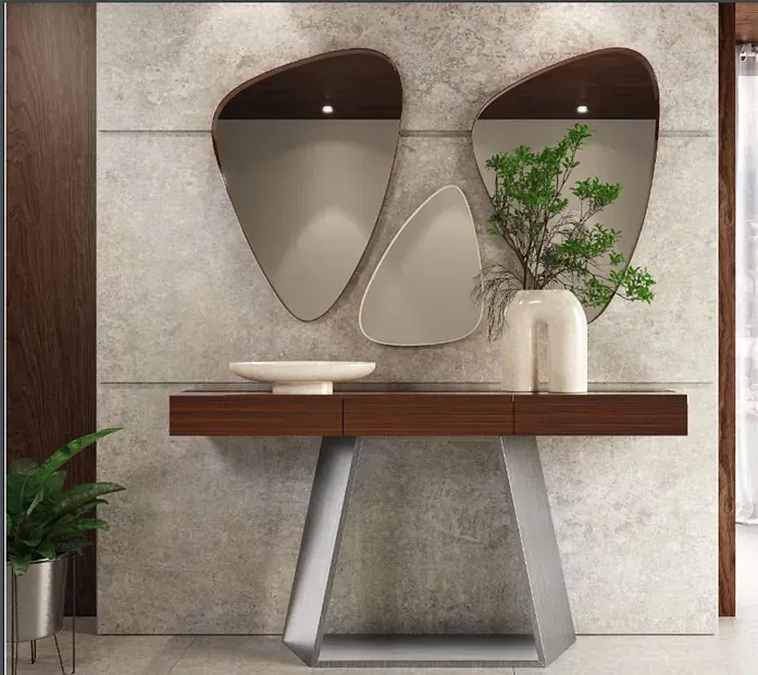 Un pasillo con una mesa y dos espejos en la pared.