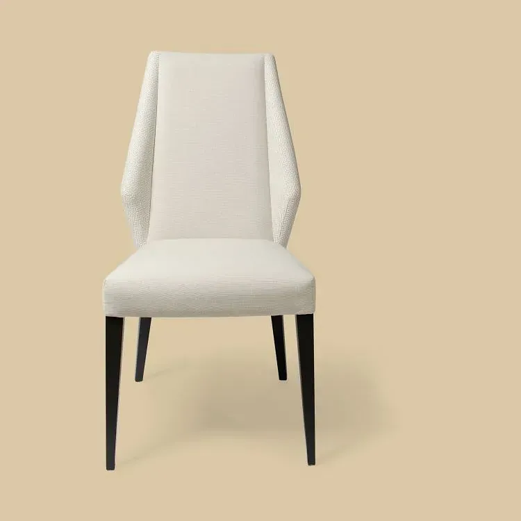 Una silla blanca con patas negras sobre un fondo beige.