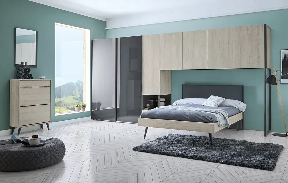 Un dormitorio con cama, tocador, espejo y alfombra.