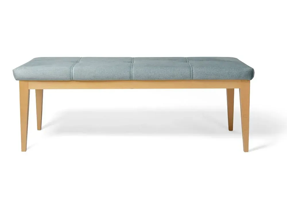 Un banco con un cojín azul y patas de madera sobre un fondo blanco.