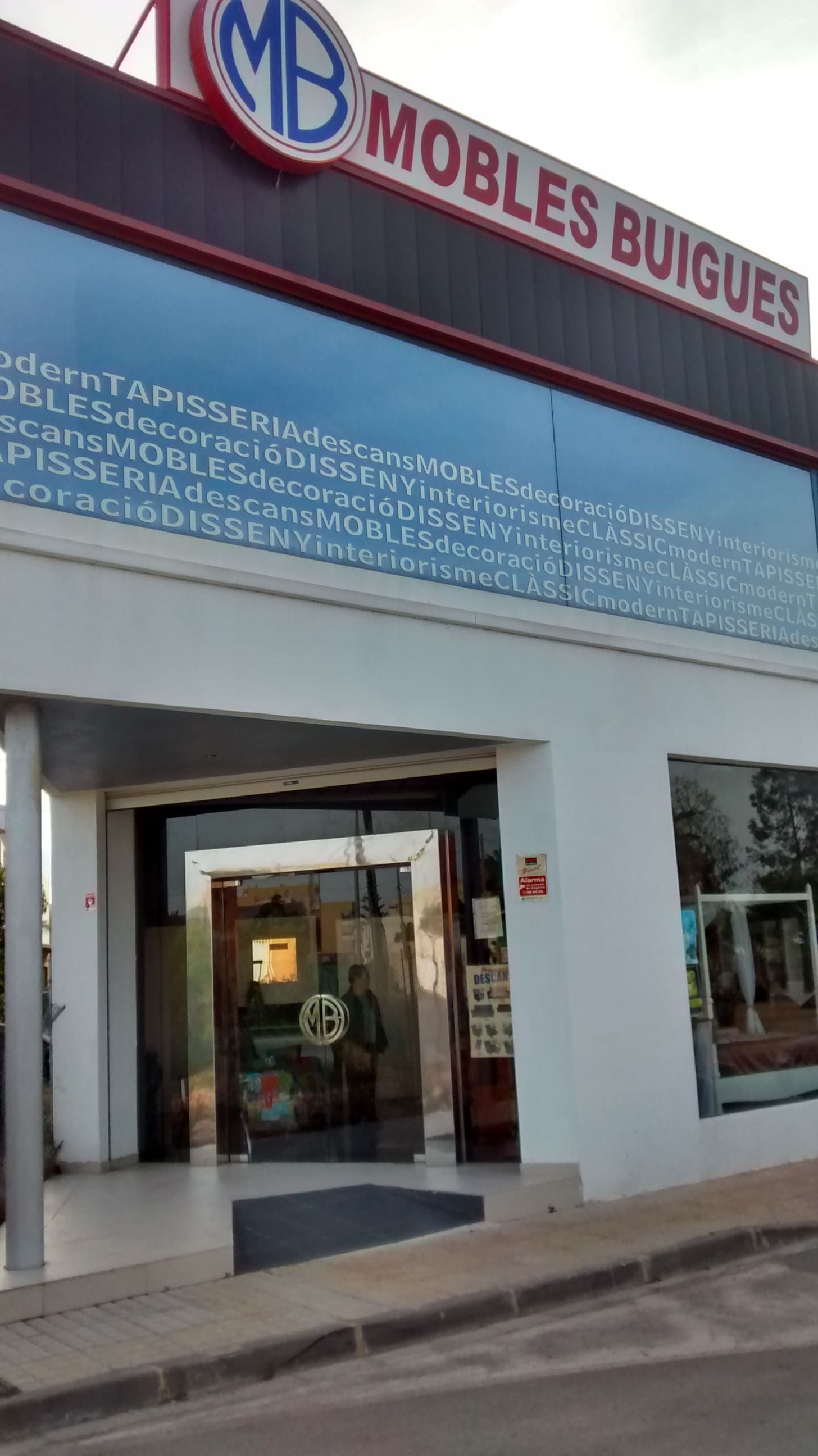 Un escaparate con un cartel que dice muebles buigues