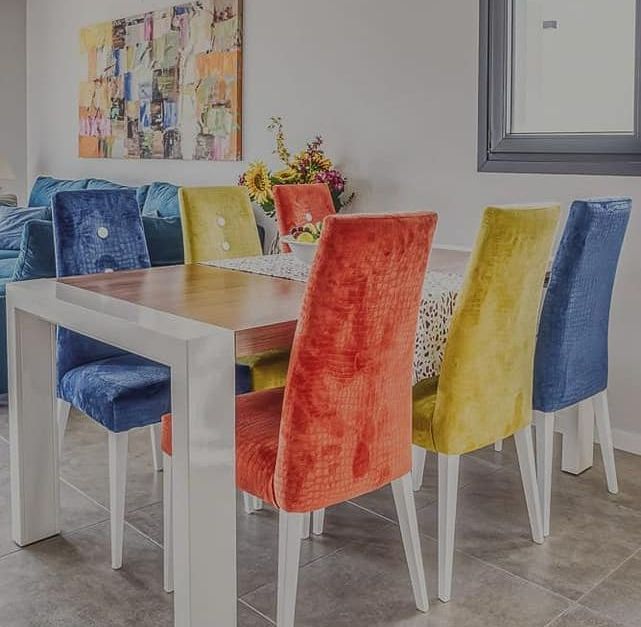 Un comedor con una mesa y sillas de colores.
