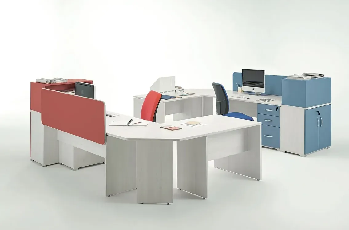 Un grupo de cubículos de oficina con mesas y sillas en círculo.